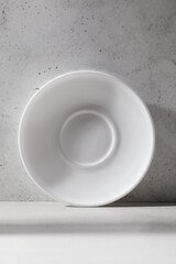 One white ceramic saucer on the table with an abstract pattern