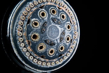 Hard water calcium or lime scale deposits on old, worn out shower head. Close up studio shot,...