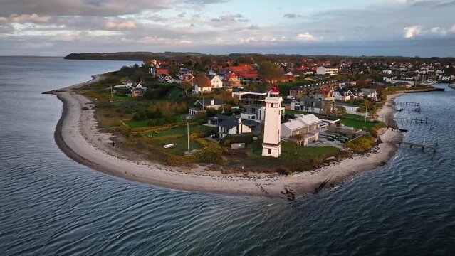 Aerial footage of Strib Odde with a beautiful view of the historic lighthouse at the entrance to the Little Belt, with a retreat movement of the camera. Shot of Middelfart on Danish coast of Funen.
