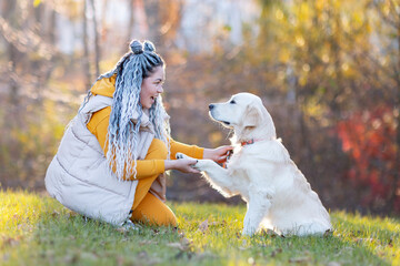 a girl greets her dog in the autumn forest