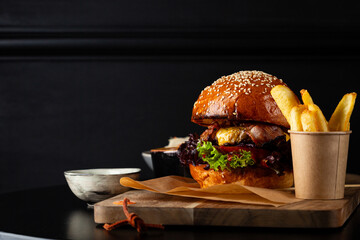 Close up of hamburger with cheese on black table fast food