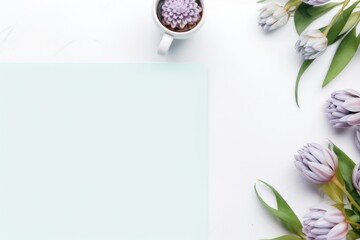 white desktop with laptop, flowers next to it, tablet