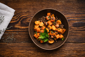 Healthy vegan meal, winter warm salad with roasted sweet potatoes, lentils and herbs