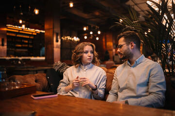 young couple in love on a date in a cafe on a cozy sofa