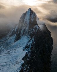 Aerial drone photo of snowy mountain hike up Segla in Senja, Norway.  Snowcapped mountains in the Arctic Circle of Northern Norway.  Famous hike on Senja island.  Shot in October - obrazy, fototapety, plakaty