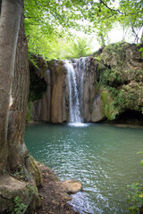 Vertical image of Blederije waterfall in the forest surrounded by greenery and trees. Djerdap, Serbia.