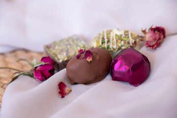 Chocolate pieces with flowers and roses on pink and white background also with mock up space