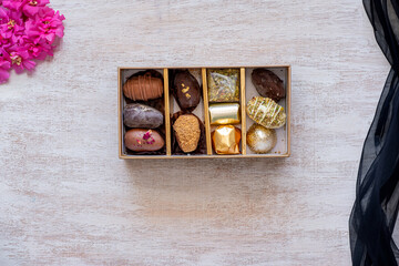 Top-View of Luxury Chocolate Box with Multiple Varieties in Stunning Golden Hues. Elegant Packaging with Copy Space. Perfect for Celebrations, Gifts, and Indulgent Occasions