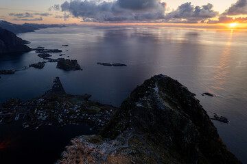 Aerial of Reinebringen mountain hike in Lofoten, Norway at sunrise / sunset.  Snowcovered mountains captured on image by a drone.  Located far North in the Arctic Circle.