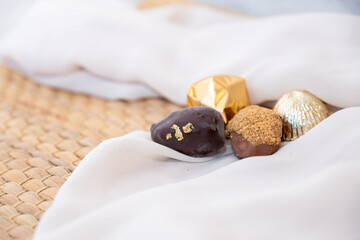 Golden Necklace and Chocolate Pieces on White Background with Elegant Mock-Up Space. Luxury Concept for Jewelry and Chocolates. Perfect for Celebrations, Gifts, and Events. with Copy Space