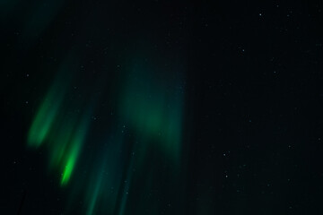Green Northern Lights Dancing in Arctic skies above Norway.  Beautiful and tranquil Aurora Borealis in the arctic circle in Northern Norway.  Shot on a mirrorless camera in the late fall near Troms
