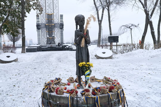 Kyiv, Ukraine - November 22, 2023: The statue of a Ukrainian child in memory of the Ukrainian Genocide "Holodomor", during a snowy day.