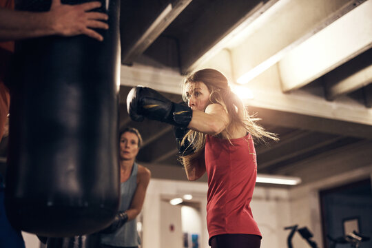 Mature woman hitting a punching bag in a boxing gym