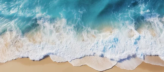 Fotobehang A clear day beach with crashing waves seen from above copy space image © vxnaghiyev