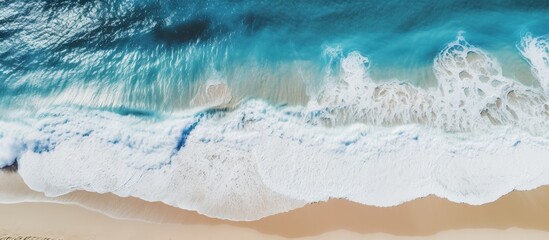 A clear day beach with crashing waves seen from above copy space image