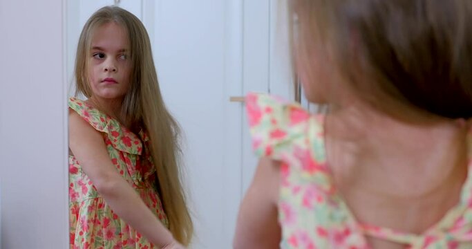 Little girl with a comb in her hands. A baby girl does her hair at home