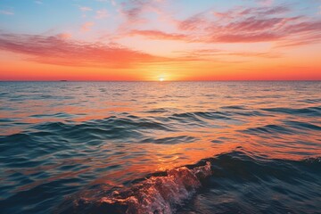 A serene sunset over a calm ocean, with the last rays of sunlight casting a warm glow on the water's surface.