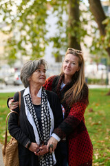 Fototapeta premium Elderly old cute woman with Alzheimer's very happy and smiling when eldest daughter hugs and takes care of her 