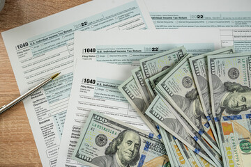 Income tax return 1040 forms with blue pen and us dollar bills at office desk - obrazy, fototapety, plakaty