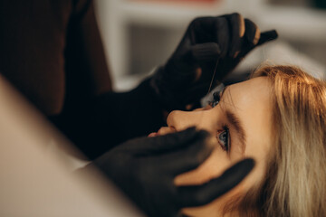 Mikrobleiding eyebrow measurement. Cosmetologist makes markings with pencil and threads for perfect shaped eyebrows. Professional makeup and facial care. Permanent makeup, tattooing of eyebrows. - obrazy, fototapety, plakaty
