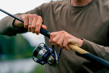 close-up Fly fisherman male hands with fishing rod or spinning in hands feeder free style method