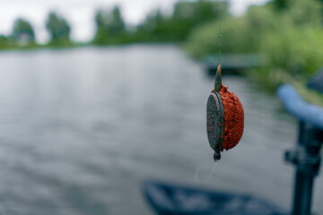 close-up fishing edible bait hanging on a hook on the background of the river nature sport fishing feeder free style method