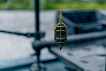 close-up fishing edible bait hanging on a hook on the background of the river nature sport fishing...