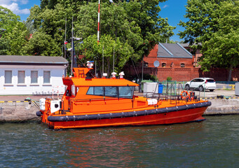 Swinoujscie. A red pilot boat moored at the pier on a sunny day.