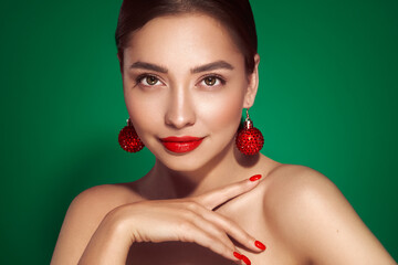 Portrait of beautiful young woman on green background, red lipstick and festive makeup, Christmas...