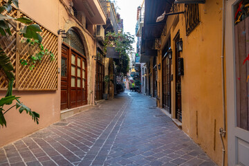 Chania Old Town Crete island Greece. Narrow empty paved street, multicolor shop, flower, summer day.