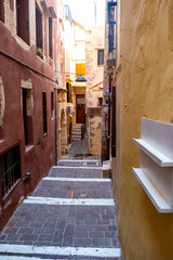 Fototapeta na wymiar Chania Old Town, Crete island, Greece. Traditional paved stone stair between aged building. Vertical