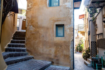 Fototapeta na wymiar Crete island, Chania Old Town Greece. Traditional peeled building, stair drives home, paved alley.