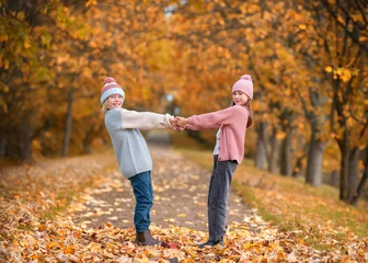 Fotobehang zwei lachend Kinder haben Spaß im Herbst und tanzen © Jenny Sturm