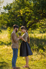 couple in nature with wildflowers, smelling a bouquet