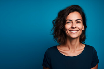 Fototapeta premium photo, smiling European woman in her 30s. blue background