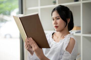 Asian woman sitting and reading a book in the break room Relaxation corner at work