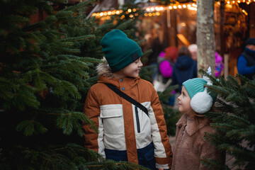 Cute little brother and sister at European Christmas market. Holidays. New Year. Winter vacation.