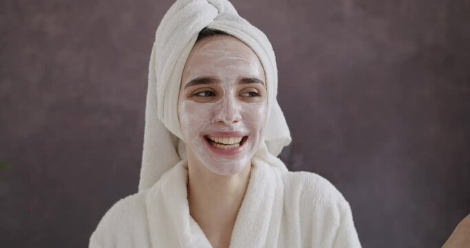 Funny happy young woman in a bathrobe with a towel on her head covering eyes with cucumbers advertising fresh clean healthy skin care concept. After Bath, Spa beauty procedures at home for lady.