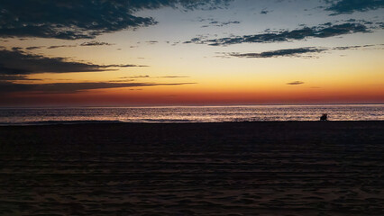 A lone person has arrived before sunrise to make sure they don't miss the Spectacular light show that is about to happen.  Sunrise over the Atlantic Ocean at Ocean City MD in late October