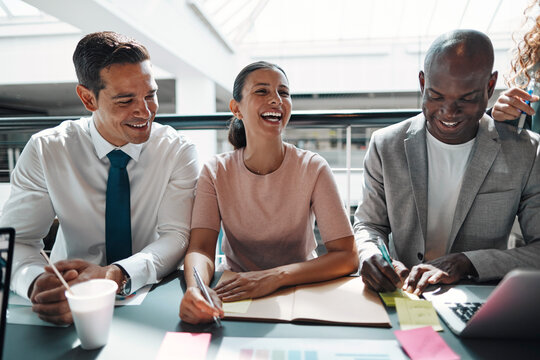 Businesswoman laughing with colleagues during an office meeting
