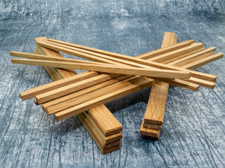 mixed stack of hardwood boards and posts  laid on concrete industrial floor