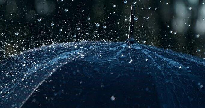 Super slow motion macro of rain water drops falling and splashing on umbrella while raining outside. Filmed on high speed cinema camera at 1000 fps.