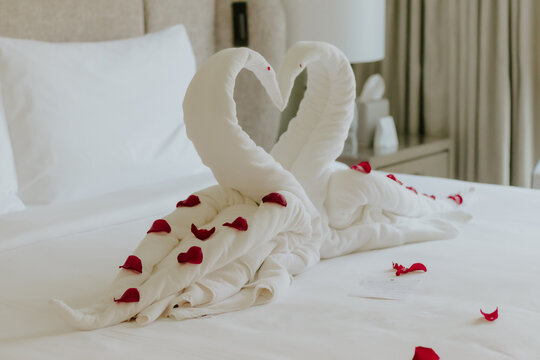 Sweet room in holiday, Swan towel decoration on bed with white pillow in bedroom interior. High quality photo