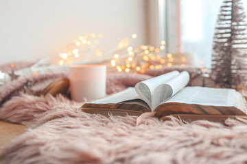 Open Bible in cozy pink winter home morning atmosphere