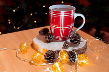 Cup of cocoa on a rustic wooden table, with earthy pine cones and a delicate light chain.  the warmth of a comforting beverage with the natural allure of pine, creating an inviting ambiance. 