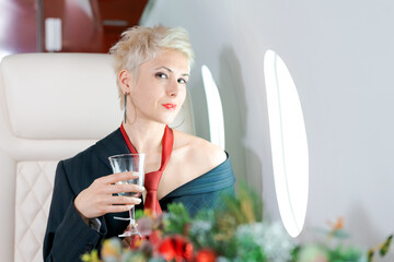 Woman private plane in a jacket with a red tie, New Year's Eve flight, holiday and travel concept.