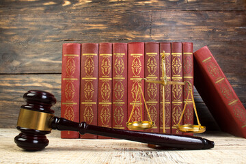 scales of justice, wooden judges gavel on law books in library of law firm. legal education concept.