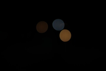 Blue and orange bokeh from lights on a black background