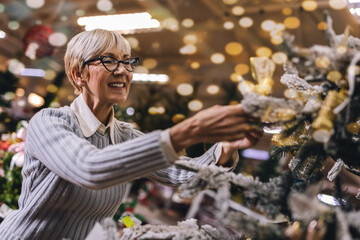 Senior couple at Christmas Market buying decor toys and balls. Concept of Christmas and New Year shopping.