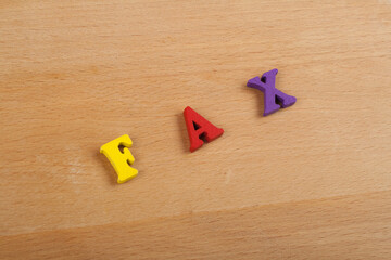 Obraz premium FAX word on wooden background composed from colorful abc alphabet block wooden letters, copy space for ad text. Learning english concept.